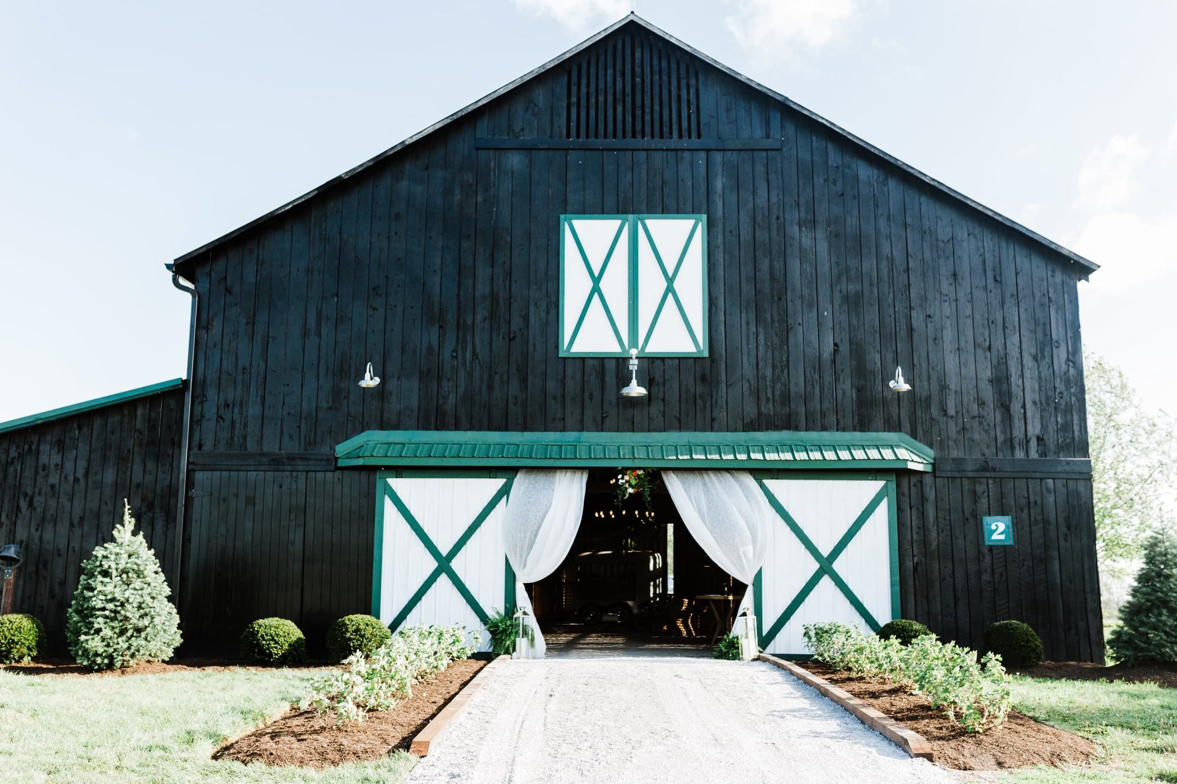 The black barn with an aisle runner leading to its doors