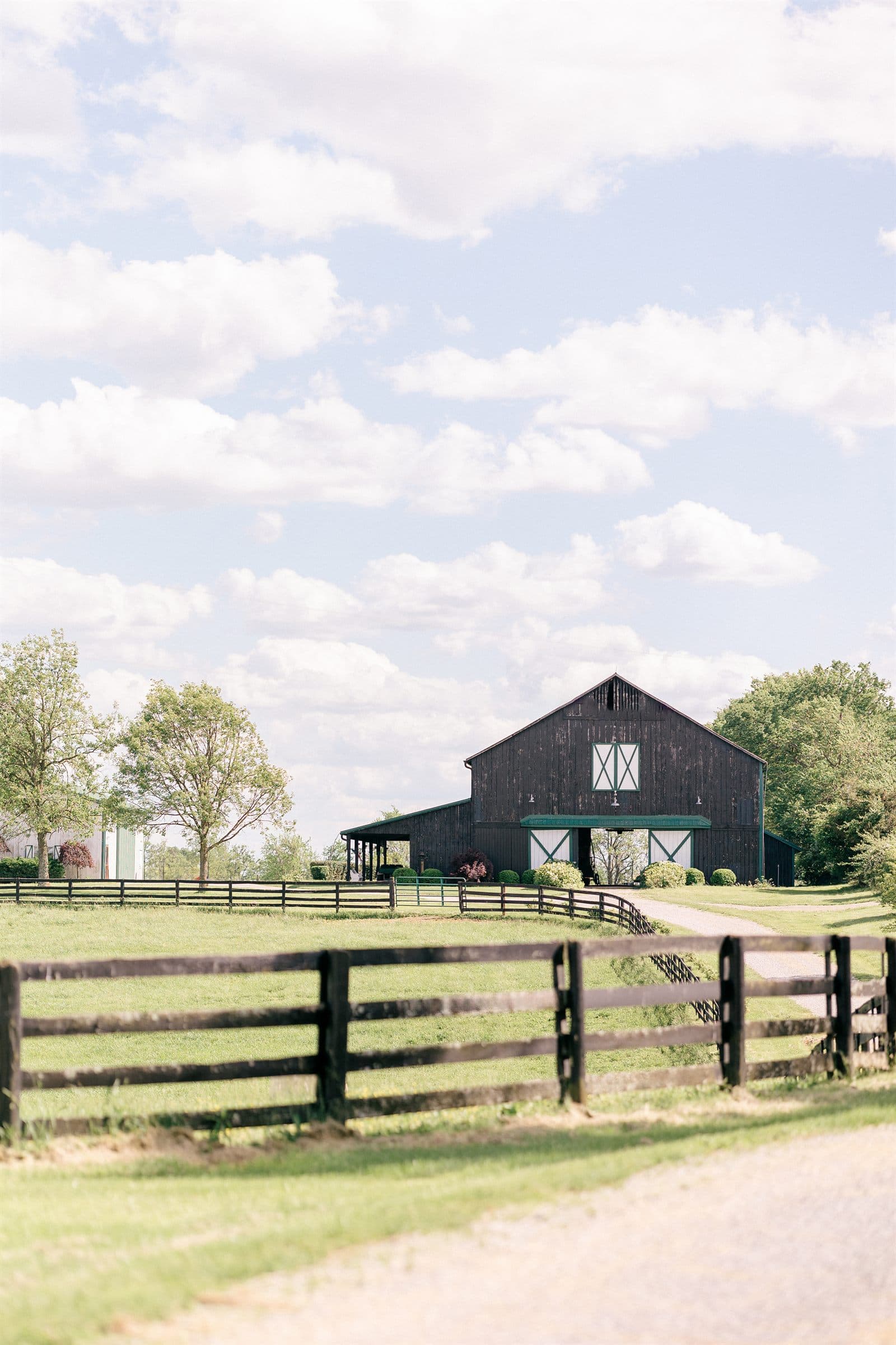 The lane past the black barn and four-board fences