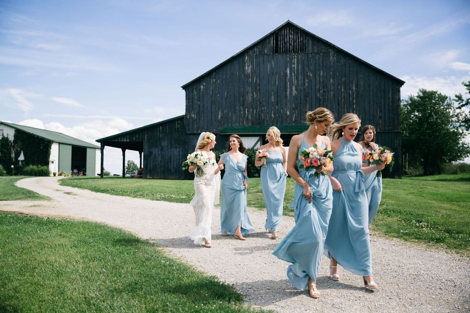 The bridal party walking from the black barn