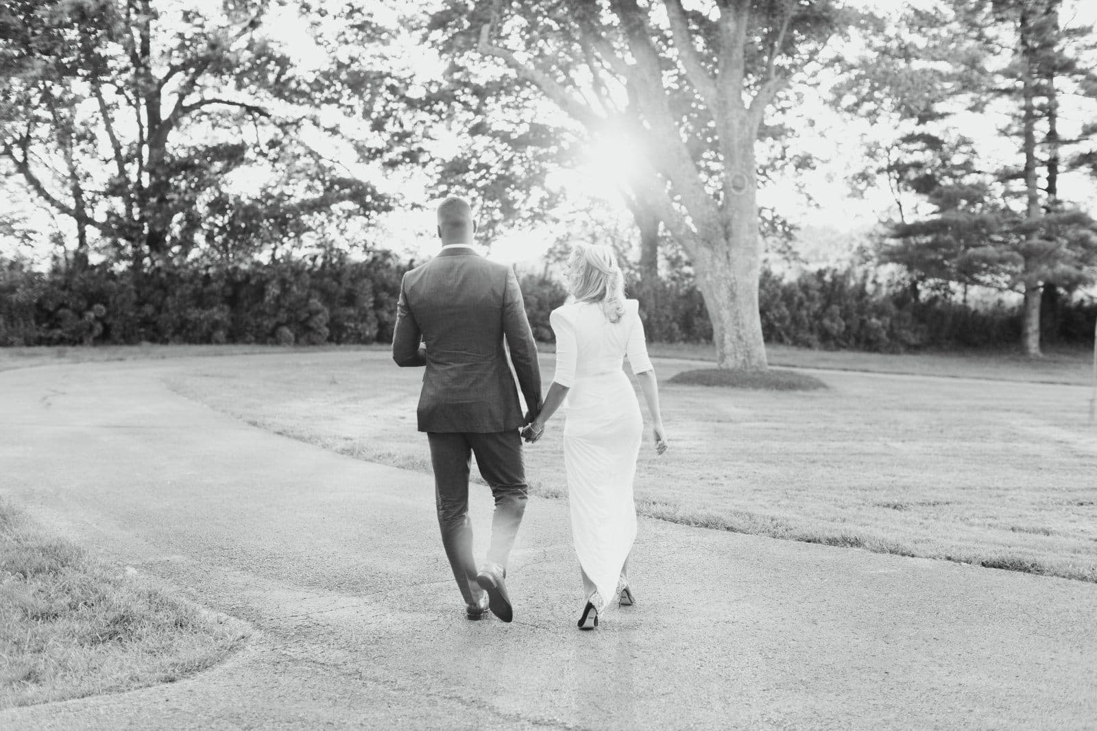 Newlyweds walking the drive at sunset
