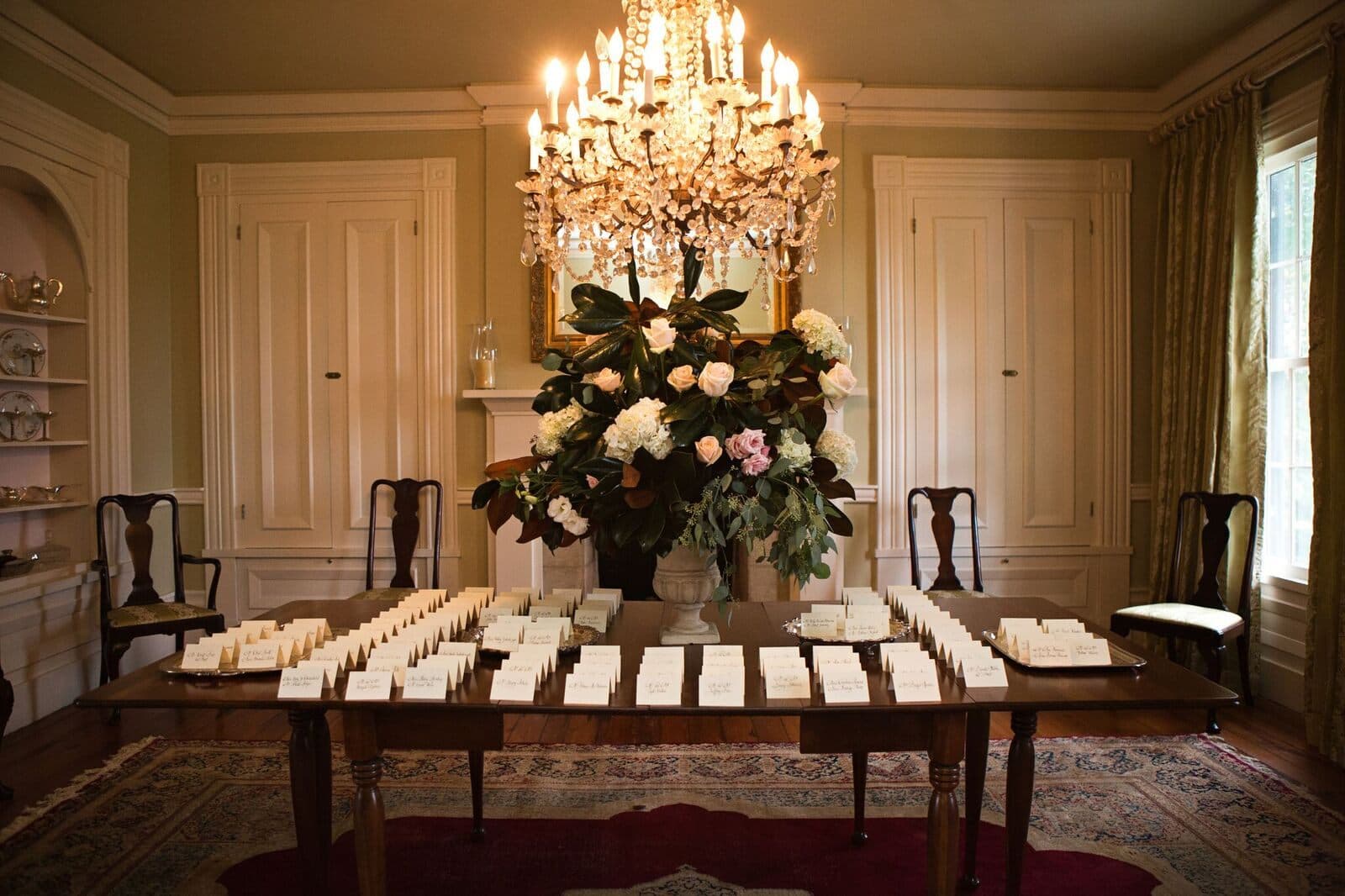 Escort cards laid out beneath the parlor chandelier