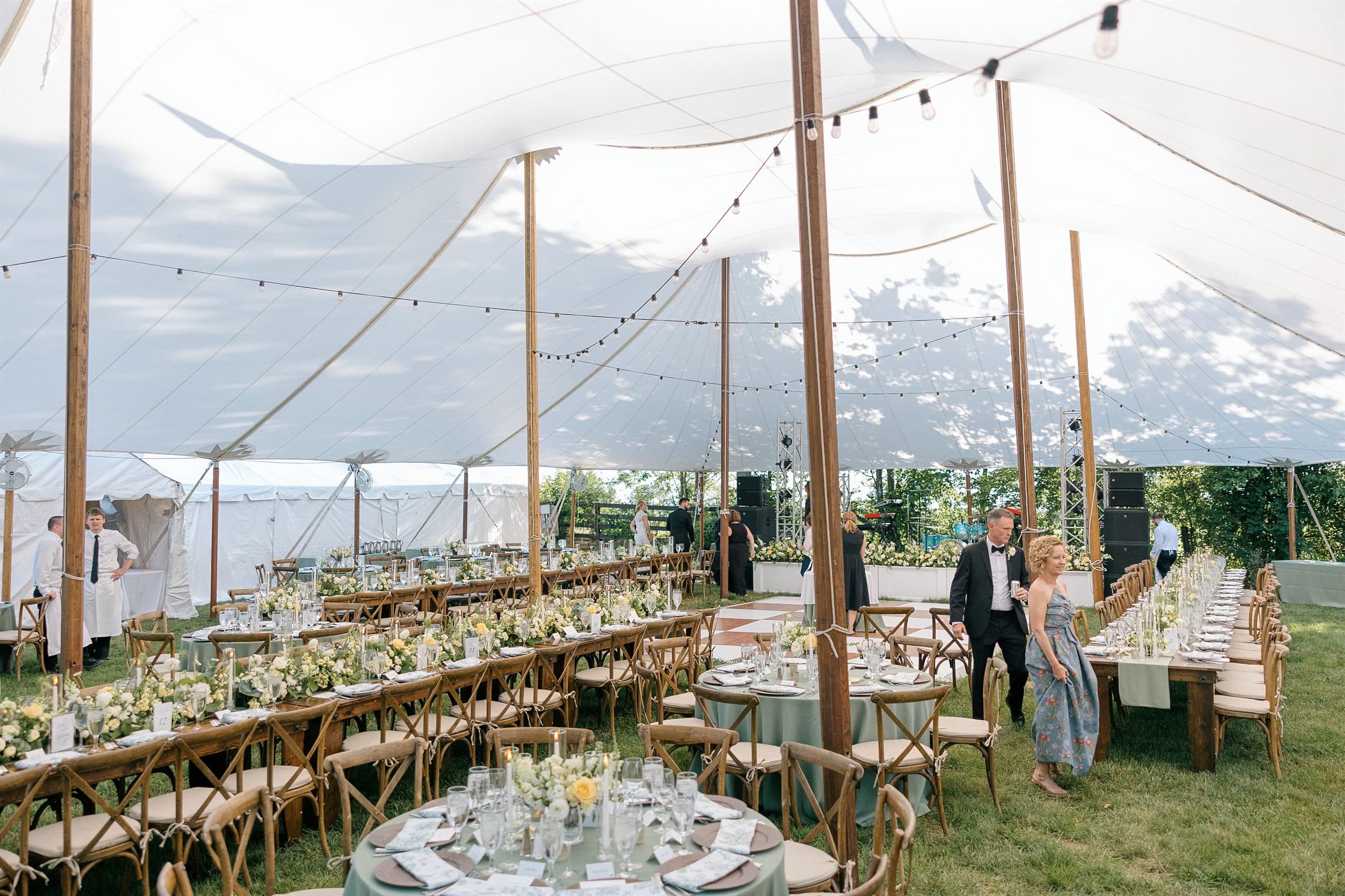 Inside the sailcloth tent, tables set beneath string lights
