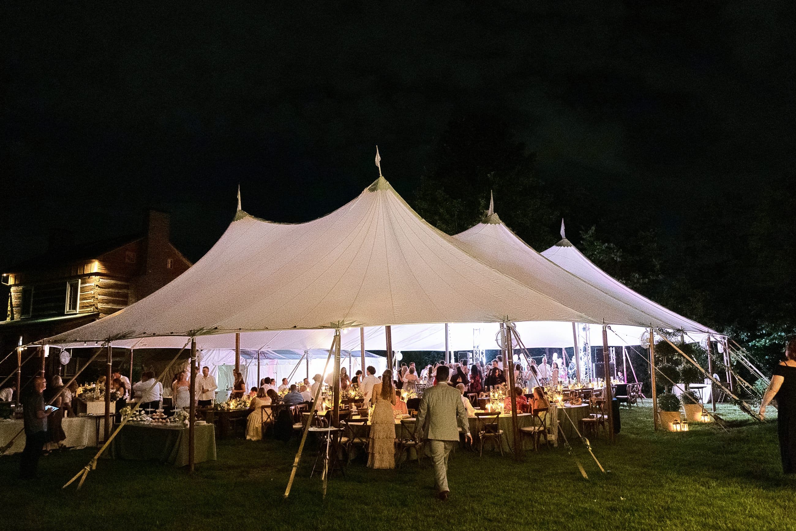 The tent glowing on the lawn after dark